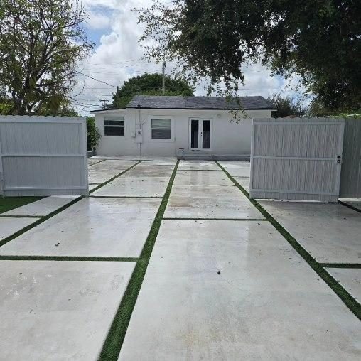 Durafence panels framing a paver driveway entry in South Florida.