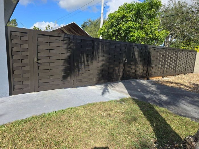 Dark brown woven-style aluminum fence with a gate.